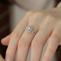 a woman's hand with a diamond ring on it