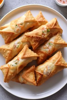 a white plate topped with wontons on top of a table