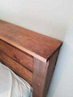 a bed with a wooden headboard and white sheets