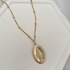 This stunning necklace is a powerful reminder of faith. Often worn to remind us of the power of trusting in prayer. Let our Mother Mary Miraculous Medal necklace be a reminder that you are held in loving protection. A powerful symbol of faith, wear it as a reminder to be open to receive its graces. Medal measure 12x21mm. 14kt gold fill or sterling medal measures 12x21mm 14kt gold fill or sterling silver satellite chain. Spiritual Miraculous Medal Pendant Jewelry, Elegant Sterling Silver Necklace With Miraculous Medal, Everyday Spiritual Necklaces, Tarnish Resistant, Spiritual Everyday Necklace Tarnish Resistant, Spiritual Everyday Necklace That Is Tarnish Resistant, Everyday Spiritual Necklace, Tarnish Resistant, Spiritual Sterling Silver Necklace With Miraculous Medal, Everyday Spiritual Nickel-free Necklace, Spiritual Nickel-free Necklaces For Everyday