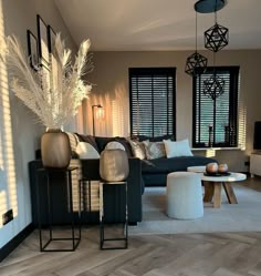 a living room filled with lots of furniture next to a window covered in shades of white