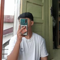 a man taking a selfie in front of a green door