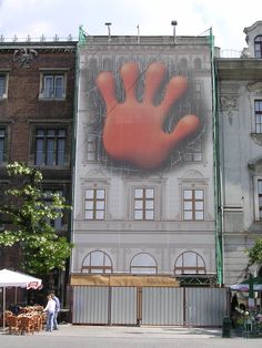 a large advertisement on the side of a building with a giant hand painted on it