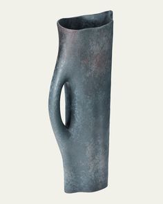 a gray vase with a curved handle on the outside of it's body is shown in front of a white background