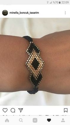 a woman's arm wearing a black and white beaded bracelet on her wrist