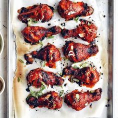 chicken wings with sauce and herbs on a baking sheet