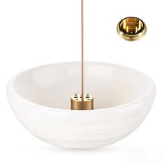 a white bowl with two gold poles sticking out of it