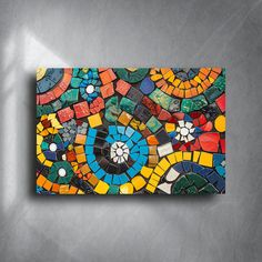 a colorful mosaic tile wall hanging on a gray wall