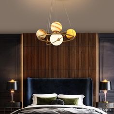 a bedroom with a large bed and two lamps hanging from the ceiling over it's headboard