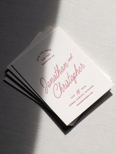 three folded wedding cards sitting on top of each other in front of a white background