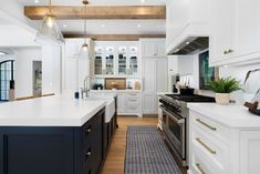 a large kitchen with white cabinets and black counter tops, along with an area rug on the floor