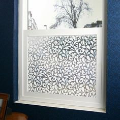 a white framed window in a blue wall with an intricate pattern on the outside and inside