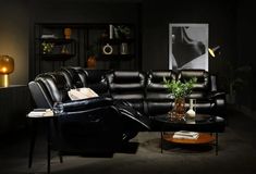 a living room filled with black furniture and decor