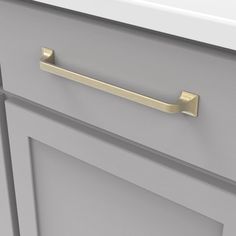 a close up of a drawer handle on a kitchen cabinet with grey paint and gold hardware