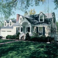 a white house sitting on top of a lush green field