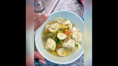 a bowl filled with dumplings and corn on top of a counter