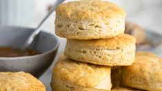 biscuits stacked on top of each other with a bowl of dipping sauce in the background