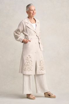 Elevate your style with our Embroidered Trench Coat, a piece of Parisian elegance, reimagined. Crafted from a lightweight linen cotton blend, this special piece features exquisite placement embroidery and delicate broderie. Other details include a self-fabricated tie, belt loops and resin buttons. The blouson sleeve with wide cuff and long split at the centre back add flair and feminine charm. For a chic, coordinated look, pair this trench with a matching linen pant. Ethereal Style, Parisian Elegance, Placement Embroidery, Resin Buttons, Linen Pant, Blouson Sleeve, Wide Cuff, Linen Pants, Tie Belt