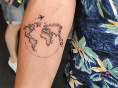 a person with a tattoo on their arm that has a world map drawn on it