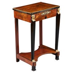 a small wooden table with gold trimmings on the top and bottom shelf, sitting against a white background