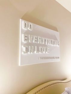 a sign that says do everything i'm love on the wall above a bed