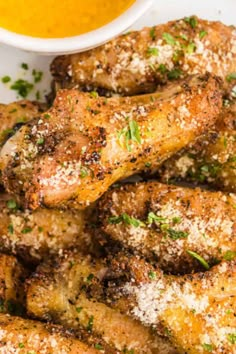 chicken wings with parmesan cheese and mustard sauce on the side, ready to be eaten