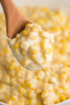 a wooden spoon full of corn and cream