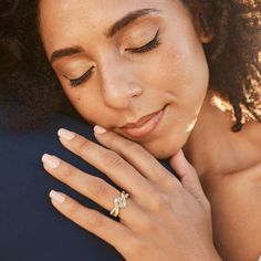 a close up of a person with a ring on their finger and her hand near her face