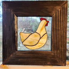 a stained glass chicken in a wooden frame