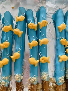 blue and yellow decorated cookies with gold fish on them