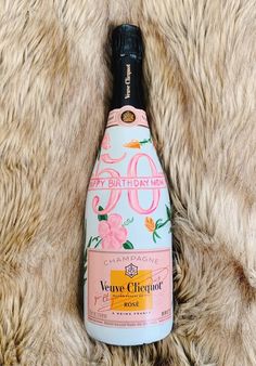 a bottle of pink wine sitting on top of a fur covered floor next to a white rug