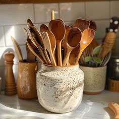 wooden spoons and spatulas in a ceramic cup on a kitchen countertop