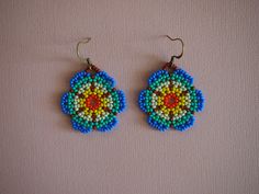 a pair of beaded earrings on a white surface