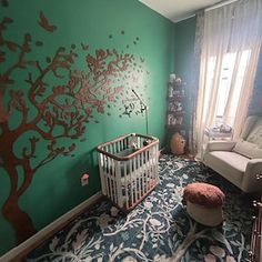 a baby's room decorated in green and pink with a tree painted on the wall