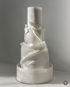 a three tiered wedding cake with white icing