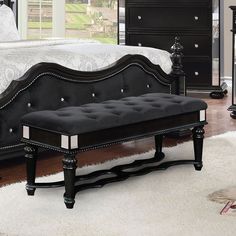 a black bench sitting in front of a bed on top of a white carpeted floor