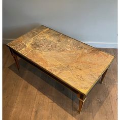 a marble top coffee table on wooden flooring in front of a gray wall and hardwood floors