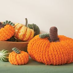 crocheted pumpkins and gourds are sitting on the table