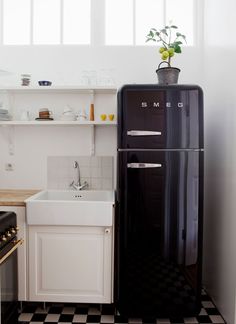 a black refrigerator freezer sitting inside of a kitchen