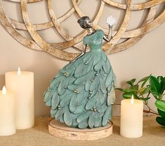 a figurine sitting on top of a table next to candles