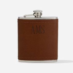 a brown leather flask with the word ams engraved on it