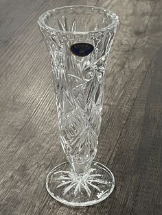 a clear glass vase sitting on top of a wooden table next to a bottle opener