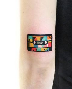 a small colorful cassette tattoo on the arm