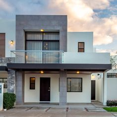 a white house with a black door and balcony