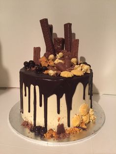 there is a cake with chocolate and nuts on the top that has been drizzled with icing