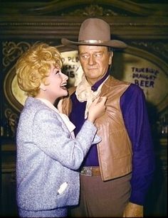 a man in a cowboy hat standing next to a woman