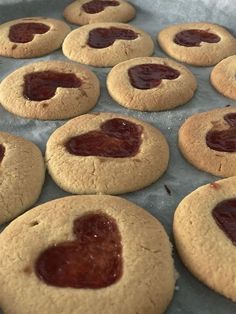 cookies with jam in the middle on a baking sheet