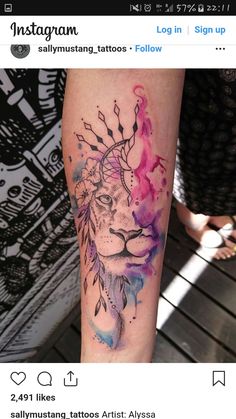 a woman's leg with a watercolor tattoo of a lion and feathers on it