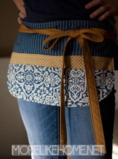 the woman is wearing a blue and white apron with an orange ribbon around her waist