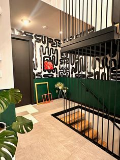 the stairs are decorated with black and white wallpaper, along with green planters